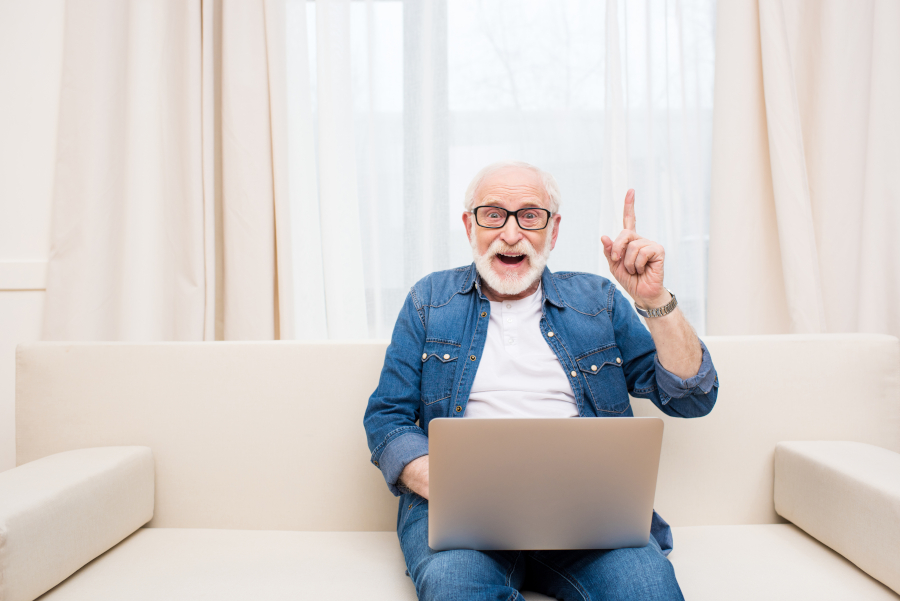 A confident retiree planning his finances at a laptop.